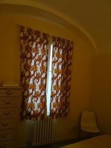 ジェノヴァにあるCasa Costa Romanticaのベッドルーム1室(窓、カーテン、牛付)