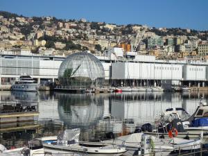 un gruppo di barche attraccate in un porto turistico con un edificio di Casa Costa Romantica a Genova