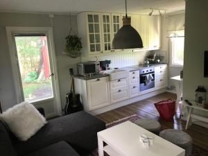 a living room with a couch and a kitchen at Gästhuset i Åselstad 1 in Norrköping