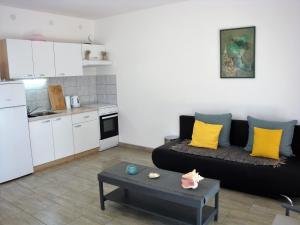 a living room with a black couch and a kitchen at Apartments Olea in Pinezici