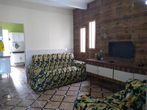 a living room with a couch and a flat screen tv at Casa da Sua Família in Mucugê