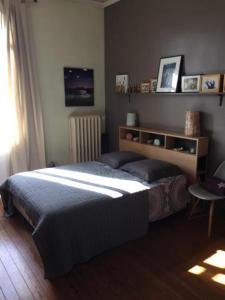 a bedroom with a large bed and a window at Au Petit Bonheur in Talence