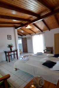 ein Schlafzimmer mit einem großen Bett in einem Zimmer mit Holzdecken in der Unterkunft Nikis Apartments in Agios Gordios