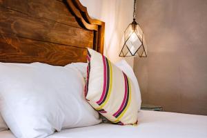 1 cama con almohadas blancas y cabecero de madera en Hotel Casa Santamaría, en San Miguel de Allende