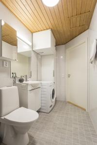Un baño con inodoro y lavadora. en Vasko luxurious suites, Ahola, en Rovaniemi
