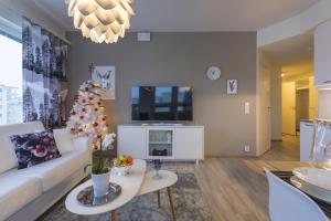 a living room with a white couch and a christmas tree at Tuomas´ luxurious suites, Ahola in Rovaniemi