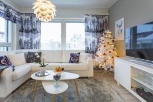 una sala de estar con un árbol de Navidad y un sofá blanco en Vasko luxurious suites, Ahola, en Rovaniemi 11 fotos más