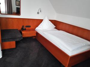 una piccola camera da letto con un letto e un tavolo di Hotel Walz a Salzkotten
