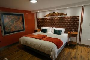 a bedroom with a large bed with a large headboard at Dolce Lobo Boutique Stay in Quito