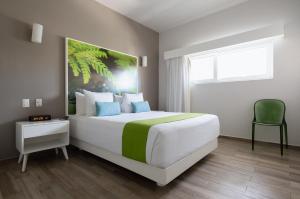 a bedroom with a large bed and a large window at Azura Boutique Hotel in Tulum