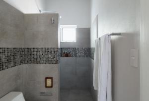 y baño con ducha, aseo y lavamanos. en Azura Boutique Hotel, en Tulum