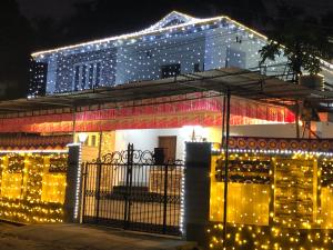a house covered in christmas lights in front of a building at Sannidhi Home stay in Guruvāyūr
