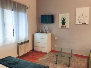 uma sala de estar com uma cama e uma mesa de vidro em MONTECERRAO I (GARAJE Y WIFI GRATIS) em Oviedo