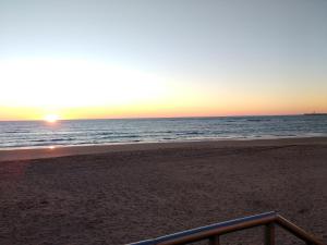 una puesta de sol en una playa con el océano en Estudio San Felipe, en Cádiz