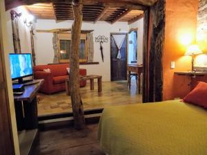 1 dormitorio con 1 cama y sala de estar en Posada La Masía en Los Reartes