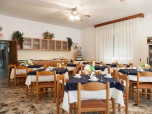 a dining room with blue tables and wooden chairs at Hotel Ronconi in Rimini