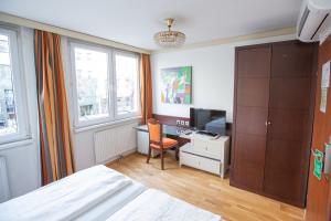 sypialnia z łóżkiem i biurkiem z telewizorem w obiekcie Hotel Attaché l contactless check-in w Wiedniu