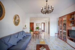 ein Wohnzimmer mit einem blauen Sofa und einem Tisch in der Unterkunft Aranci 77 Sorrento in Sorrent