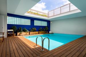 a swimming pool with a wooden deck and blue walls and a ceiling at Casas Da Formiga - Riverview Terrace and Pool in Porto