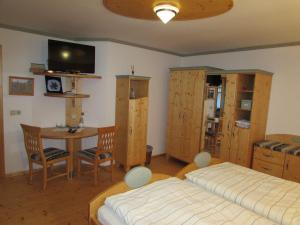 Schlafzimmer mit einem Bett, einem Tisch und einem TV in der Unterkunft Arkadenhof Fam. Schneider in Eichenbrunn