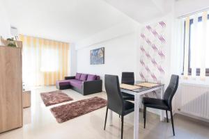 a living room with a table and a purple couch at Miraj Apartaments - Exclusive Residence in Mamaia