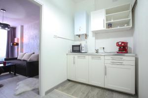 a kitchen with white cabinets and a red appliance at Simona Maria in Bucharest