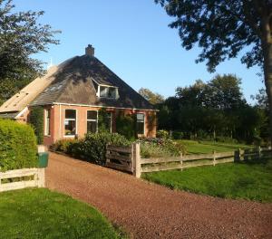 a house with a fence in front of it at Rêst en Romte in Birdaard