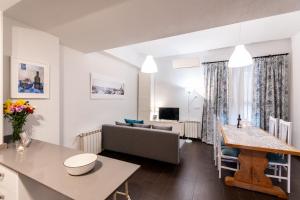 a kitchen and living room with a couch and a table at 1 habitación Apartamento in Madrid