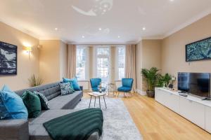 ein Wohnzimmer mit einem Sofa und einem TV in der Unterkunft Luxurious Central Kensington Apartment in London