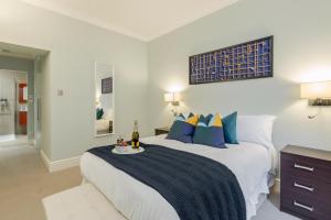 a bedroom with a large bed with blue pillows at Luxurious Central Kensington Apartment in London