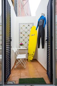 un traje de neopreno y una tabla de surf en una habitación en Casas Burnay I, en Ericeira