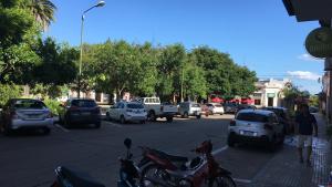 een drukke straat met auto's en voertuigen geparkeerd bij Apartamento para 8 personas frente a la plaza principal Mercedes Uruguay in Mercedes