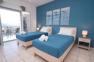 duas camas em um quarto com paredes azuis em Sami View em Sami