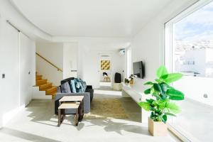 uma sala de estar com paredes brancas e uma grande janela em Casas Barulho Penthouse Old Town em Albufeira