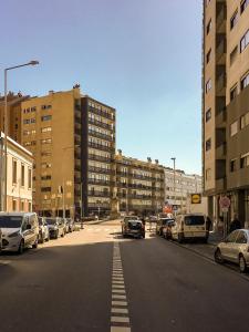 eine Stadtstraße mit am Straßenrand geparkten Autos in der Unterkunft Apartamento da Praia - Surf in Matosinhos
