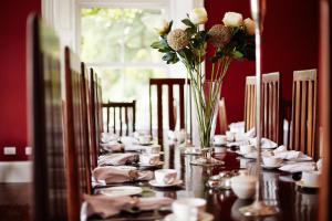 a long table with a vase of flowers on it at Barnabrow Country House in Killinagh