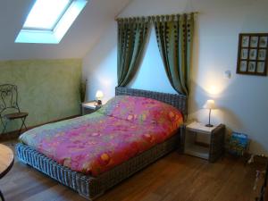 a bedroom with a large bed with a pink blanket at Gît' Âne Evasion in Le Bec-Thomas