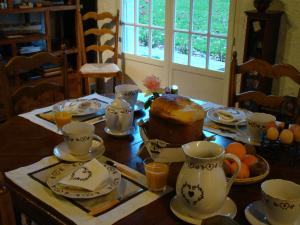 a dining room table with a cake and cups on it at Gît' Âne Evasion in Le Bec-Thomas