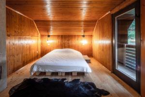 una camera da letto con letto in una camera in legno di Idyllic cottage in beautiful Alps a Zgornje Jezersko