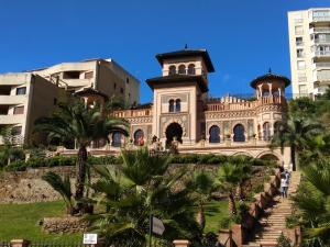 a building in a city with palm trees and buildings at Apartamento Torremolinos Centro in Torremolinos