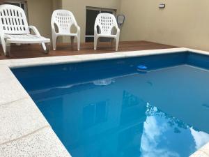 2 sillas y una piscina de agua azul en Cactus 1 en Salta