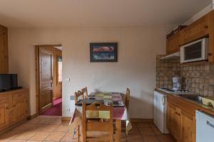 a kitchen with a table and chairs in a kitchen at appartement T2 LES HOUCHES Pied des Pistes in Les Houches