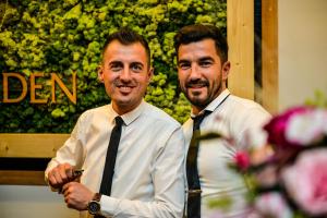 Due uomini in cravatta sorridono per la telecamera. di Hotel SunGarden Salin a Turda