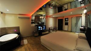 a bedroom with a bed and a tv in it at Eros Hotel - Adult Only in Recife