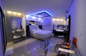 a bedroom with a bed and a bathroom with a sink at Eros Hotel - Adult Only in Recife
