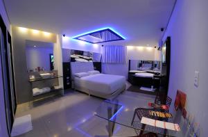 um quarto com uma cama e uma casa de banho com um lavatório em Eros Hotel - Adult Only no Recife