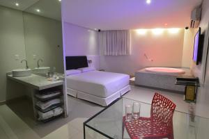 a hotel room with a bed and a bathroom at Eros Hotel - Adult Only in Recife