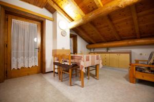 Giacomino Apartment في ليفينو: غرفة طعام مع طاولة وكراسي خشبية