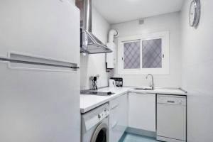 a white kitchen with a sink and a refrigerator at Apartamento Noemi in Barcelona