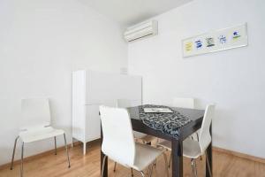 a dining room with a black table and white chairs at Apartamento Noemi in Barcelona